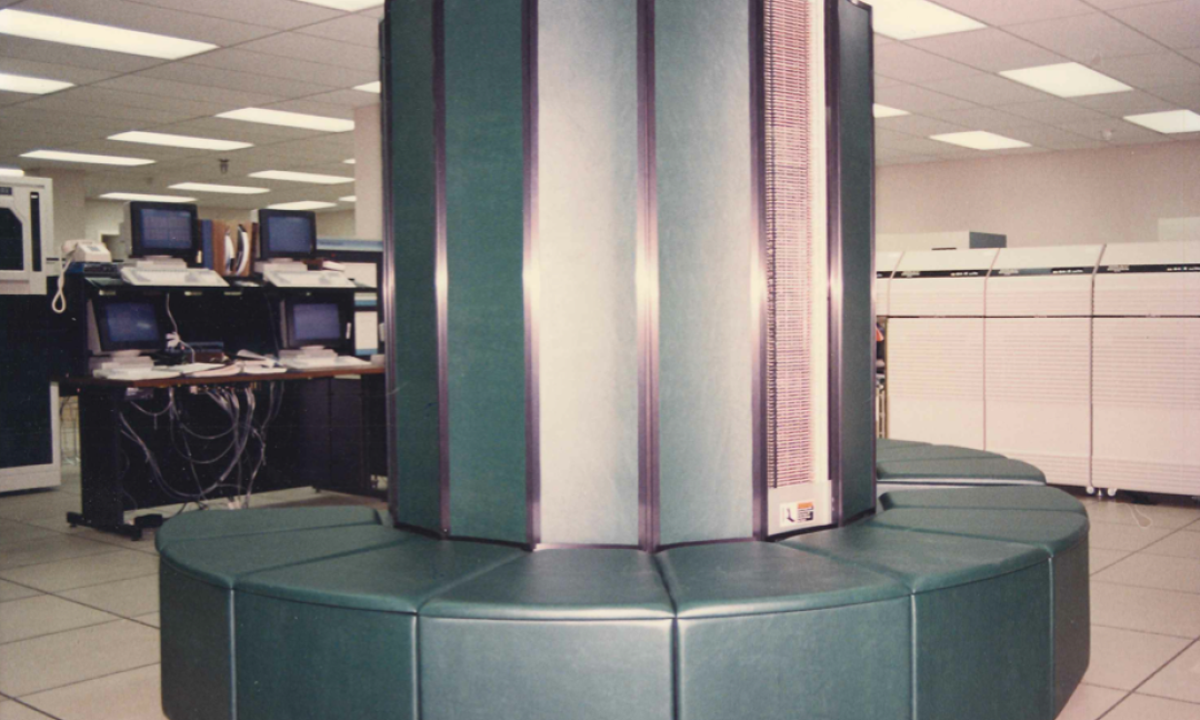 ASA's tall cylindrical dark green Cray XMP Supercomputer with surrounding upholstered bench in the Alabama Supercomputer Center after installation in November 1987