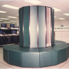 ASA's tall cylindrical dark green Cray XMP Supercomputer with surrounding upholstered bench in the Alabama Supercomputer Center after installation in November 1987