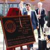 Outdoor photo of unveiled bronze dedication plaque on an easel naming the Alabama Supercomputer Center after governor George C. Wallace